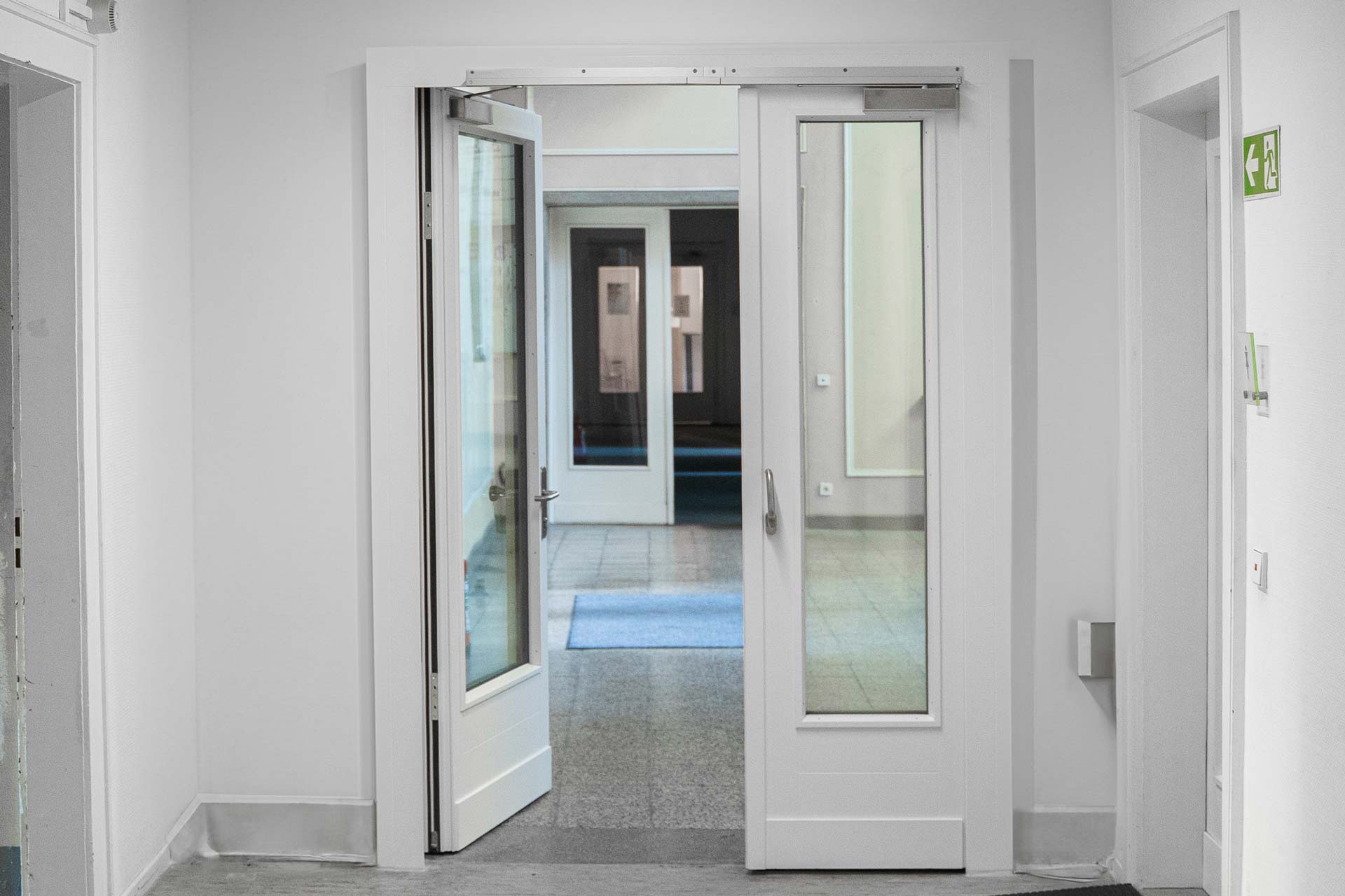 Partially open double-leaf fire door with fixed frame in the interior of the Beelitz fire protection joinery.
